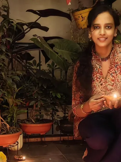 A quiet moment holding a diya during the Karthigai Deepam festival, surrounded by my plants.