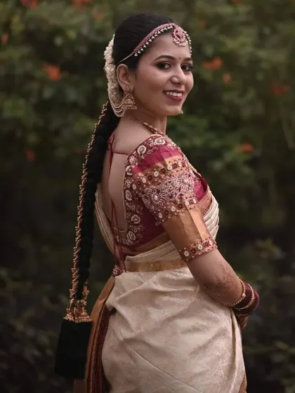 A beautiful smile from a happy client. She is wearing a classic off-white and gold saree, which we paired with a rich maroon blouse featuring intricate zardosi and beadwork.