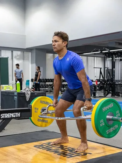 An athlete performs a trap bar deadlift, a safer and highly effective alternative for building lower body strength and power. This exercise is a staple in our S&C programs for developing functional strength.