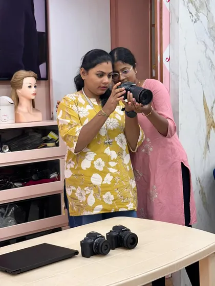 A trainer guiding a student on how to frame a shot and use the camera settings correctly.