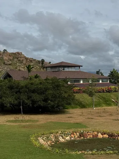 A wide view of the retreat grounds, showing the yoga shala and the rocky hill behind it. This image gives a sense of the space and freedom you have to roam and reconnect with yourself.