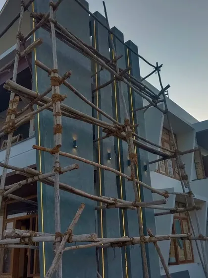 A closer look at the exterior work on a modern home. The scaffolding is essential for detailed work, especially on architectural features and different wall textures.