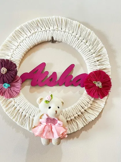 A sweet and simple personalized name hoop for Aisha. This design includes a cute teddy bear and floral accents, making it a lovely welcome gift for a newborn.