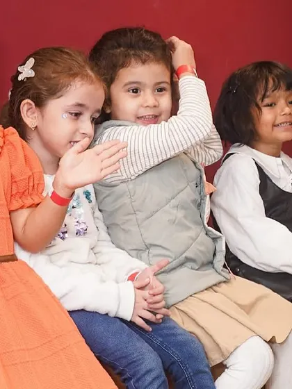 A group of young girls clapping and singing along during the party entertainment.