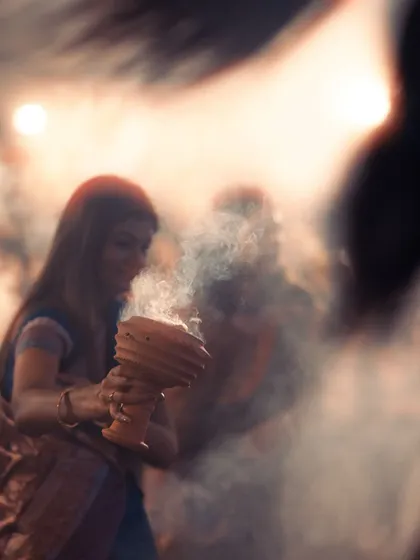 A woman participates in the Sandhya Aarti, her face illuminated by the warm glow. Capturing these moments of pure devotion is what I love about festival photography.