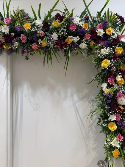 For a more modern take on entrance decor, I created this asymmetrical floral arrangement. It features a mix of colorful roses and chrysanthemums, creating a dynamic and stylish welcome.