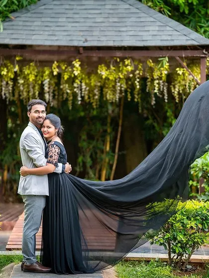 A beautiful full-length shot of a couple in a garden, with the dramatic sweep of the bride's dress adding to the romance.