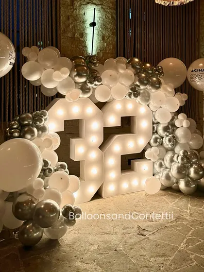 Another angle of the 32nd birthday marquee light setup. The personalized balloons with the birthday boy's name add that extra custom detail that makes it special.