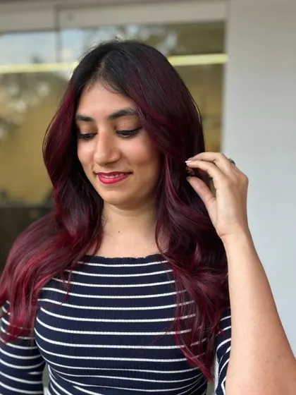 A candid shot of the client enjoying her new red-highlighted hair.