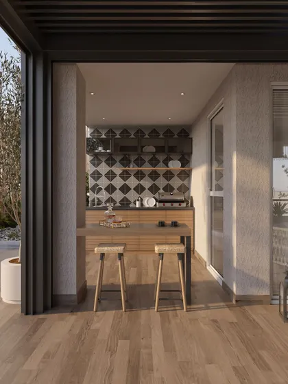 A compact outdoor kitchen and bar area is tucked into a corner of the terrace. The patterned tile backsplash adds a graphic element, while the wooden countertop and stools maintain a warm, natural feel, making it a perfect spot for casual entertaining.