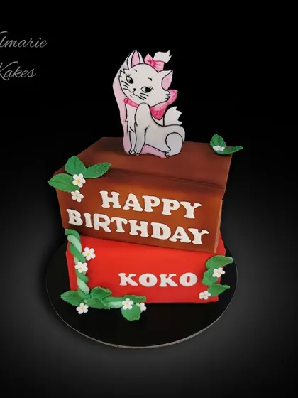 My first book stack cake, made for a cat lover. This red velvet cake is designed to look like two books, topped with a hand-painted figure of Marie from The Aristocats.