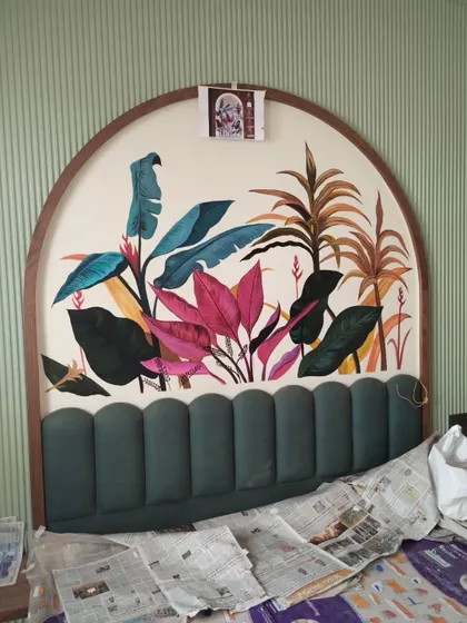 The tropical mural in progress, showing the initial color blocking and composition above the upholstered headboard.