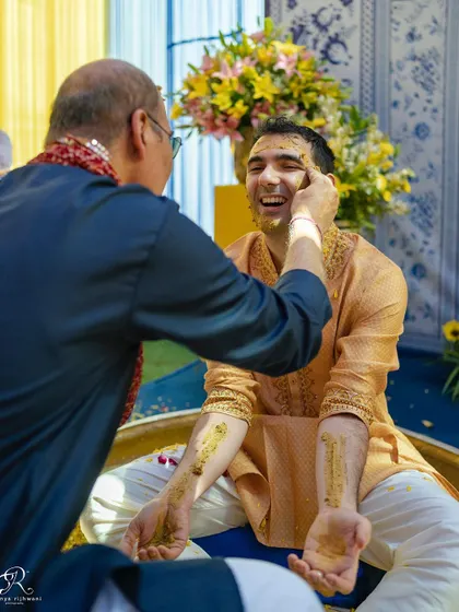 More laughter and fun as the groom gets covered in haldi by his family.