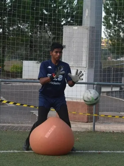 A close-up of Sunay during a goalkeeping drill in Portugal, showcasing his technique and concentration.