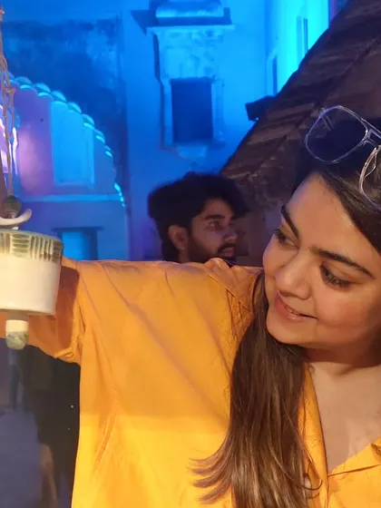 A young customer enjoying the sound of one of my ceramic bells at the Bhopal Potter's Market at night. The festive lights created a magical atmosphere.