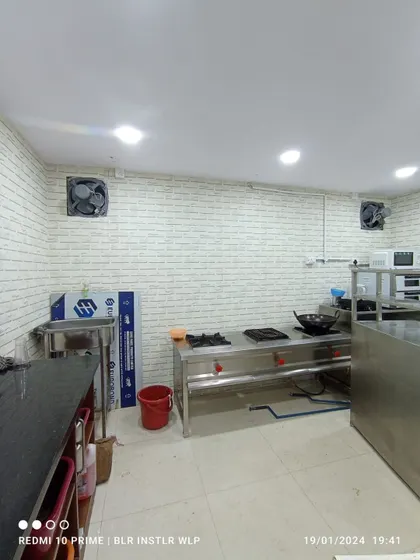 A commercial kitchen with white brick wallpaper.