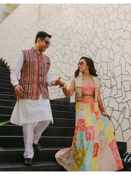 The couple walking hand-in-hand down a modern staircase, a stylish and happy portrait.