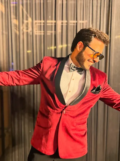 A candid dance move captured in a stylish red tuxedo, ready to bring life to the party.