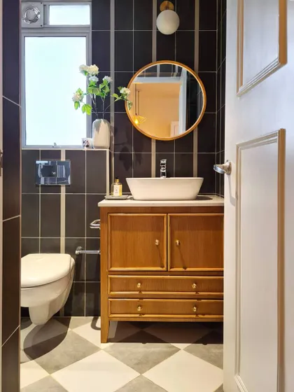 For the guest bathroom in the Breeze Home, I created a warm and rustic feel with classic checkerboard floor tiles. The vanity, with its beaded front detail, is a custom piece I designed to be both beautiful and functional.