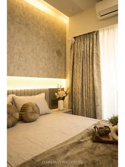 This parent's bedroom features a textured accent wall with concealed lighting, creating a soft, ambient glow. The design is simple, elegant, and incredibly calming.