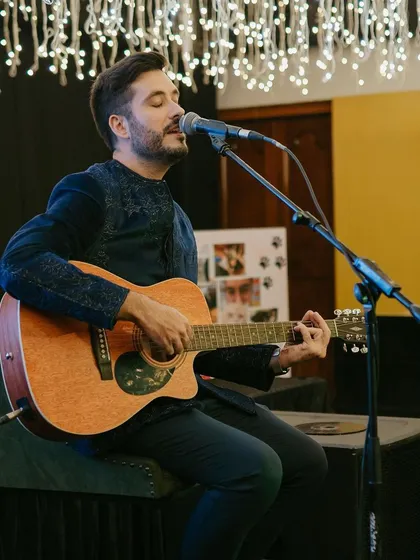 A live musician plays the guitar, providing soulful entertainment for the guests during the reception.