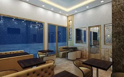 A perspective of the cafe interior showing the tufted booth seating and the textured stone column. This view highlights how we use different materials and furniture styles to define zones within a larger open space.