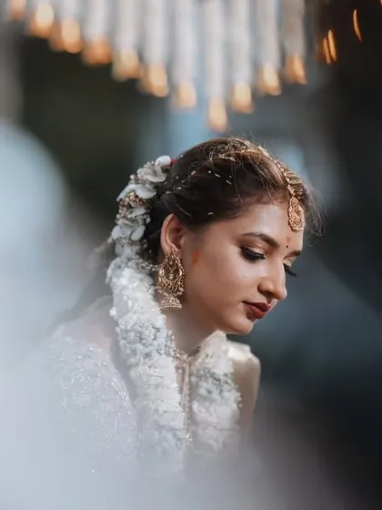 A candid portrait of the bride, framed by out-of-focus elements. This technique creates a sense of intimacy, as if we are catching a private, beautiful moment.