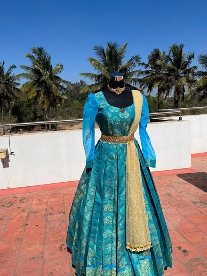 The rich silk fabric and gold belt add a touch of luxury to this gown.