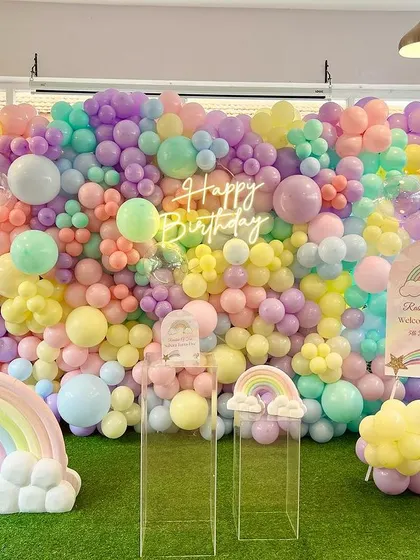 We built this incredible floor-to-ceiling pastel rainbow balloon wall as the centerpiece for Suhani's fifth birthday. The setup is completed with 3D rainbow props and a neon 'Happy Birthday' sign, creating a joyful and picture-perfect backdrop.