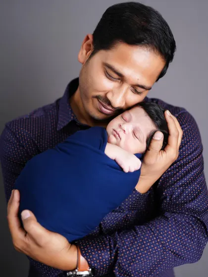 The special bond between a father and his newborn, captured as he holds his sleeping baby close to his chest.