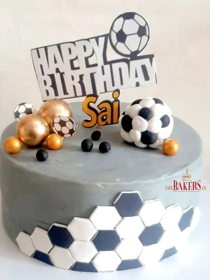 A stunning no-fondant cake for Sai, who is a big football fan. The grey cake is accented with a black and white hexagon pattern, and the fondant footballs add a fun, thematic touch.