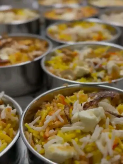 A close-up of our delicious biryani packed in individual steel containers, ready to be sent out for delivery. Perfect for a satisfying meal.