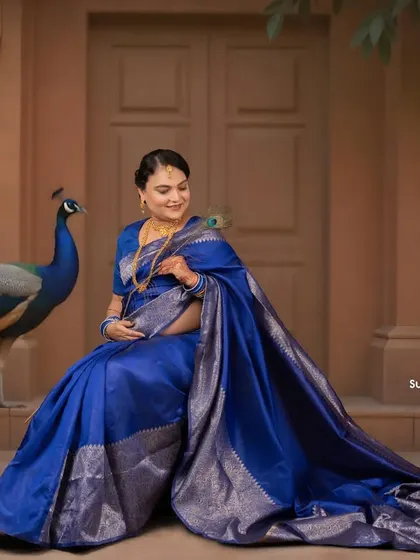 A majestic portrait featuring a live peacock, adding a touch of royal splendor to this blue saree maternity shoot. We can arrange for unique props to make your session special.