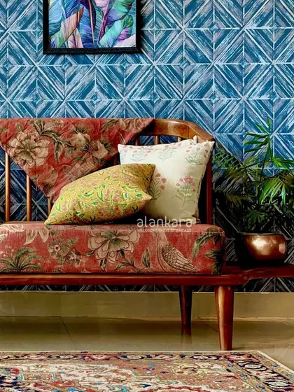 A full view of the Sabyasachi-upholstered sofa set against a bold blue geometric wallpaper, demonstrating how I mix patterns and colors to create vibrant interiors.