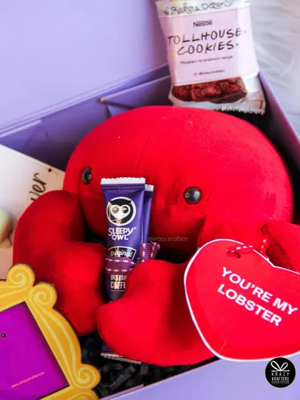 "You're my lobster!" A F.R.I.E.N.D.S themed hamper perfect for your special someone, featuring the iconic lobster plushie, a peephole frame, and Phoebe's grandma's cookies.