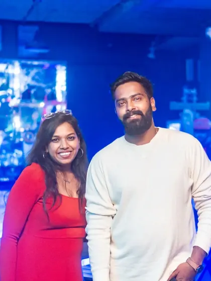 A couple enjoying the party, with the neon lights of the bar creating a cool, modern feel.