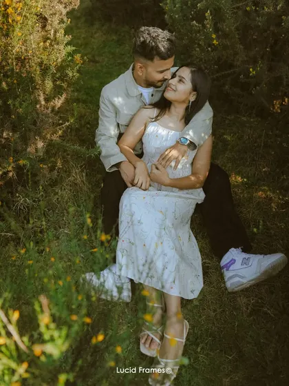 An overhead shot of the couple relaxing in a field of flowers, creating a unique and artistic perspective.