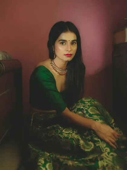 A full-length portrait from my "MEERA" series. The use of shadow and a single warm light source creates a pensive mood, drawing attention to the model's expression and the rich texture of her green brocade skirt.