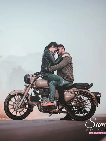 An adventurous and romantic post-wedding shot on a Royal Enfield. This image captures the couple's edgy style and intimate connection on the open road.