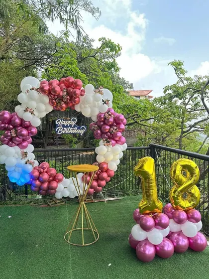 Another angle of the vibrant 18th birthday setup, showing the beautiful natural background which complements the pink and white balloon decor.