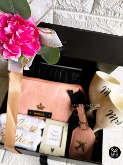A travel-themed couple's hamper, perfect for an anniversary or wedding gift. It includes personalized luggage tags, 'Mr & Mrs' wine glasses, and a pouch.