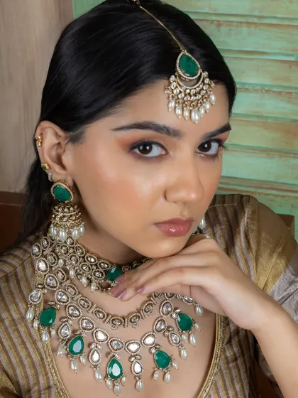 This image captures the elegance of our emerald Kundan bridal set, including the jhumka-style earrings and matching maang tikka.