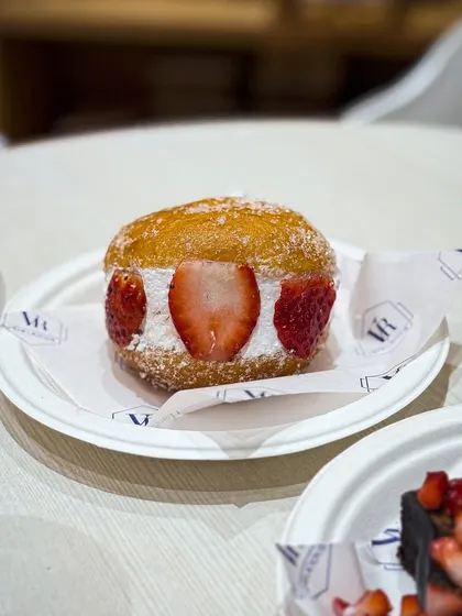 Our Strawberry Berliner, plated and ready to be enjoyed. We use fresh strawberries to fill these during the season, making them extra special.