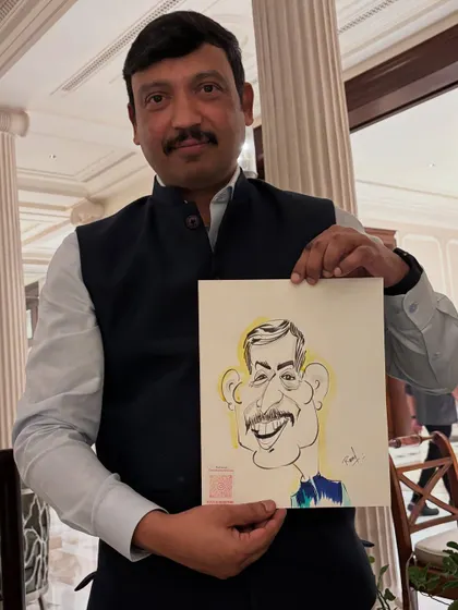 A guest at a private party, holding up his caricature with a gentle smile.