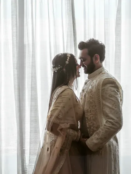 A soft and romantic silhouette against a sheer curtain. This intimate portrait captures the couple's closeness in a gentle and artistic way.