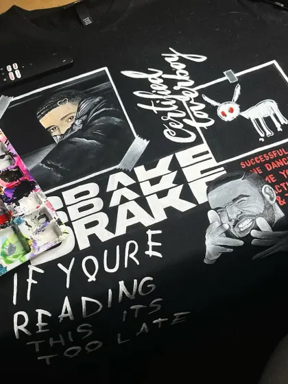 A custom t-shirt I painted with a collage of Drake album art, including 'Certified Lover Boy' and 'If You're Reading This It's Too Late'.