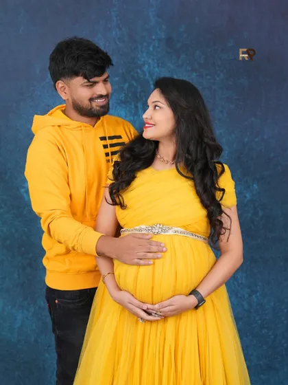 A coordinated couple's look. The parents-to-be both wear bright yellow, creating a cheerful and unified portrait that radiates happiness.