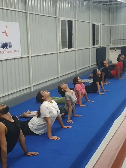 The cobra pose is a fundamental exercise for building back flexibility and strength, practiced here by our dedicated adult gymnastics class.
