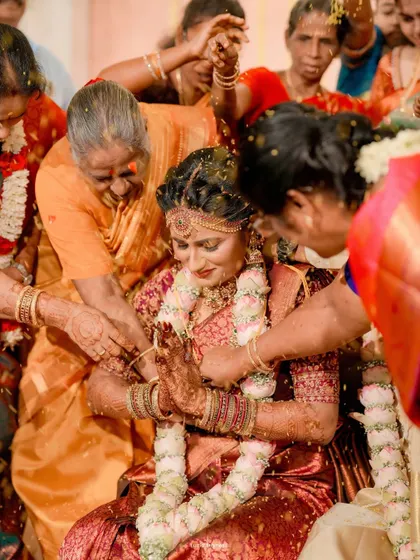 The bride being blessed by her elders with rice and flowers, a beautiful and significant moment in a Hindu wedding.