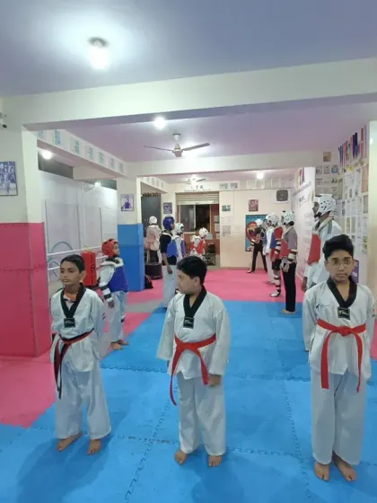 Students getting ready for a sparring session, putting on their protective gear.